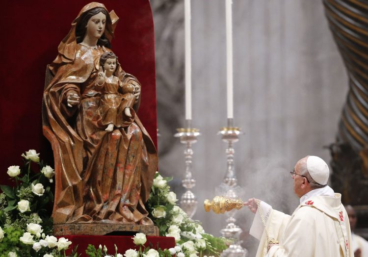 Pope Francis swings the incense burner to bless a statue of the Virgin Mary as he leads a solemn mass in Saint Peter's Basilica at the Vatican
