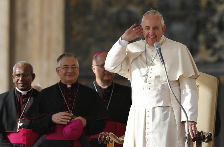 Pope Francis gestures towards crowd as he begins general audience in St. Peter's Square at Vatican