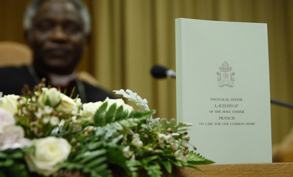The English edition of Pope Francis' encyclical on the environment is pictured during a news conference at the Vatican June 18. The encyclical is titled, "Laudato Si', on Care for Our Common Home." At left is Cardinal Peter Turkson, president of the Pontifical Council for Justice and Peace. (CNS photo/Paul Haring) See stories slugged ENCYCLICAL- June 18, 2015.